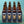 A square image with a pale blue background showing 12 brown glass bottles of XT Brewing Co's Golden Fleece beer featuring a ram's face.